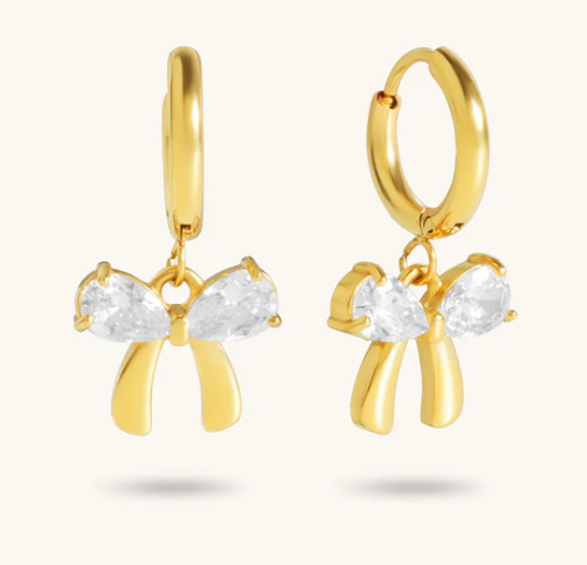 Gold hoop earrings with bow-shaped pendants on a white background